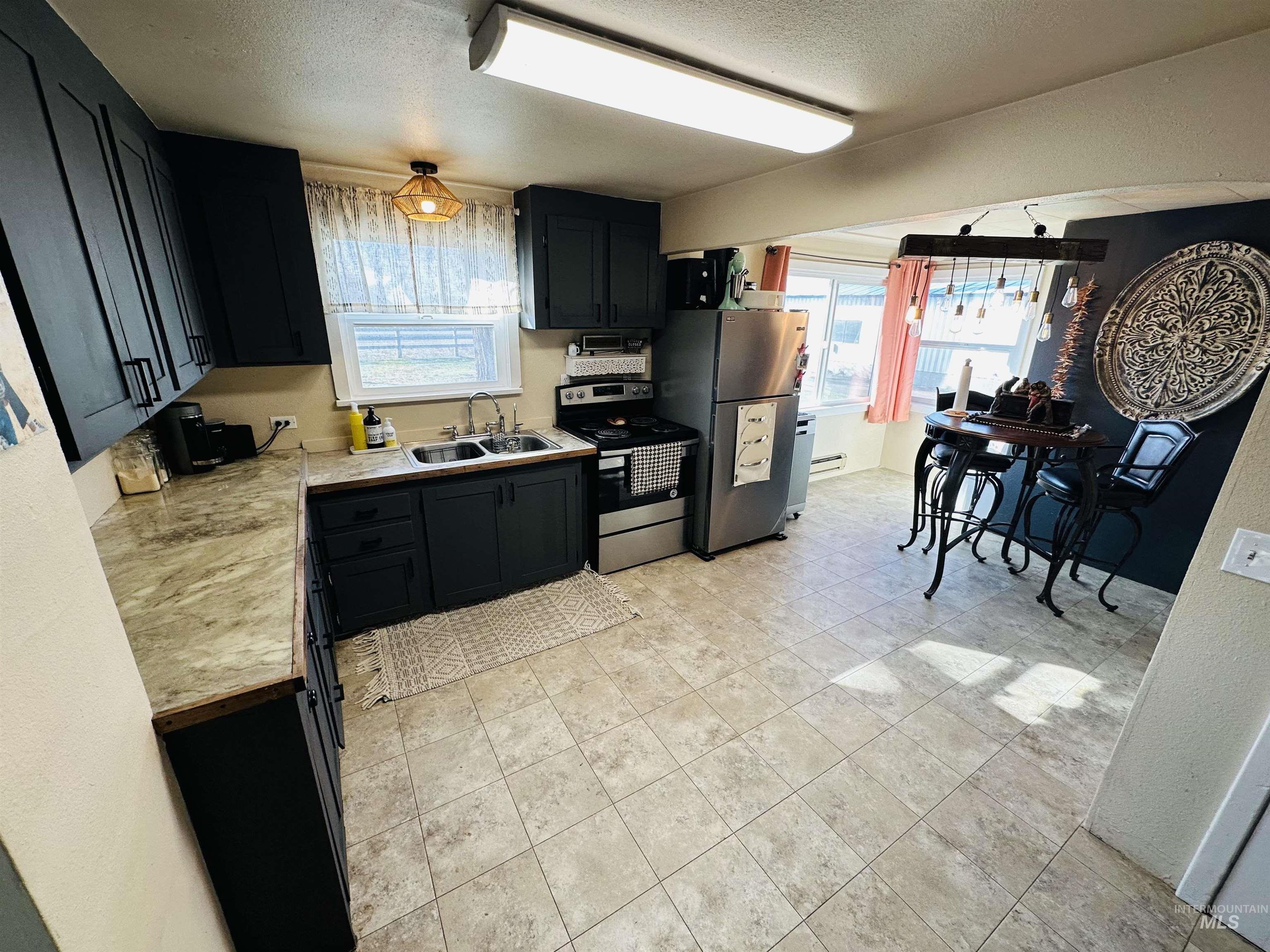 260 Highway 95 Weiser, ID 83672 - Photo 4 of 31 Kitchen featuring light countertops, dark cabinetry, appliances with stainless steel finishes, and a textured ceiling