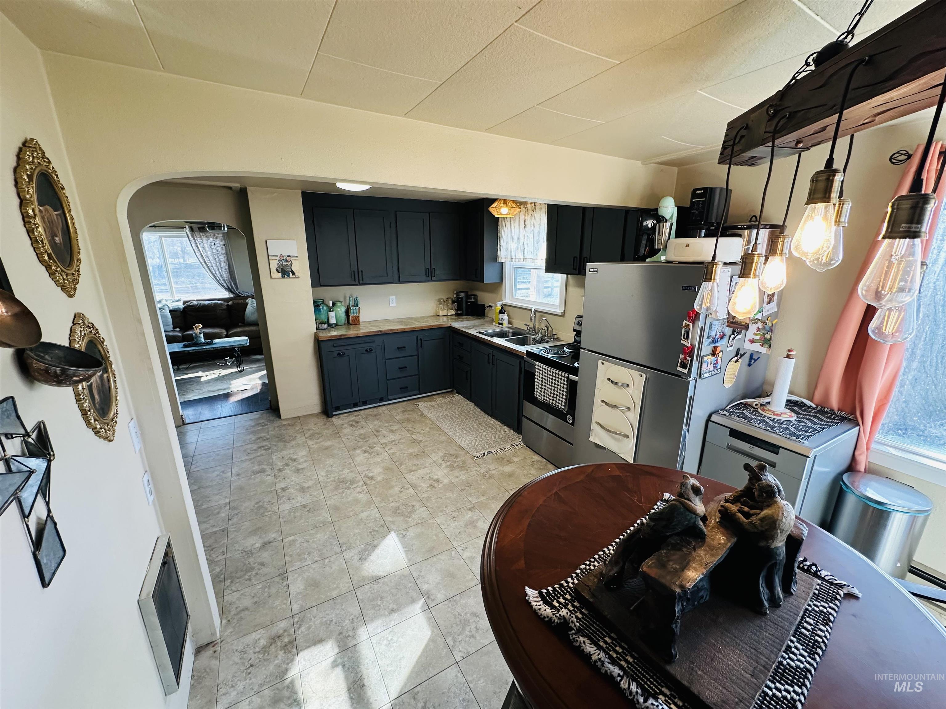 260 Highway 95 Weiser, ID 83672 - Photo 5 of 31 Kitchen with arched walkways, appliances with stainless steel finishes, heating unit, light countertops, and light tile patterned flooring