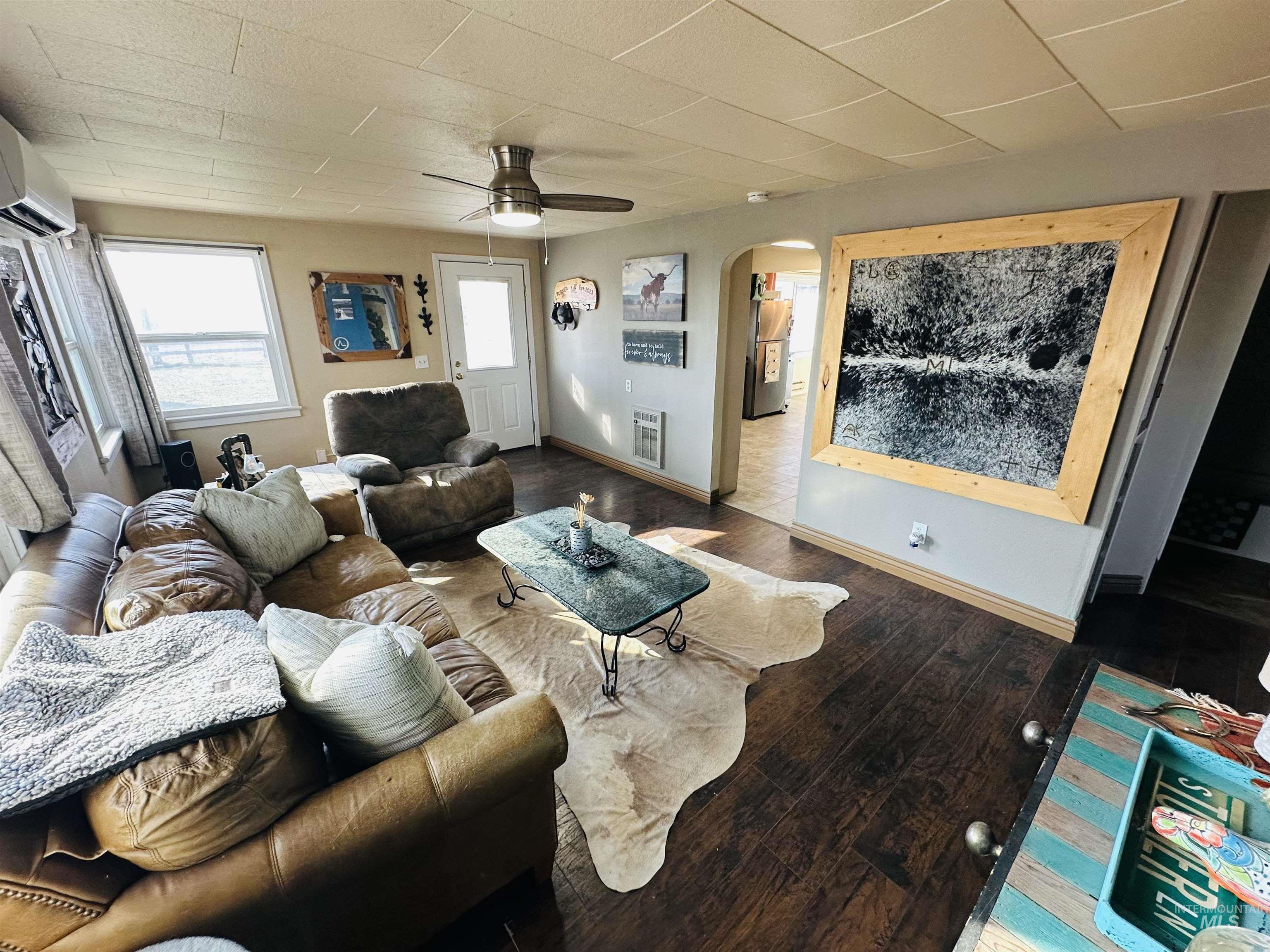 260 Highway 95 Weiser, ID 83672 - Photo 10 of 31 Living area with arched walkways, hardwood / wood-style floors, a ceiling fan, heating unit, and a wall mounted air conditioner