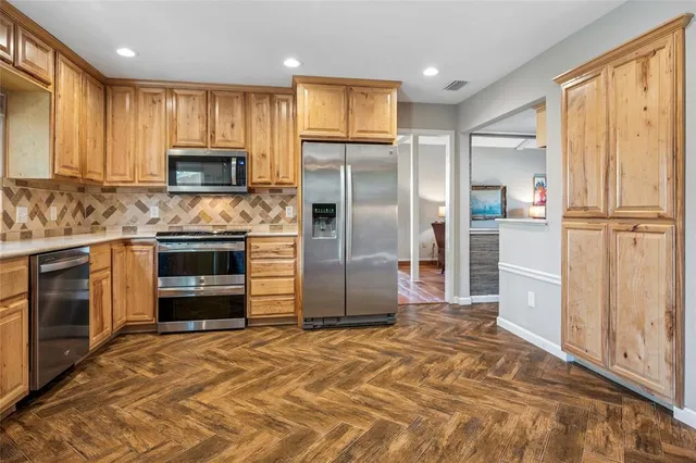 a kitchen with stainless steel appliances granite countertop a refrigerator and a stove