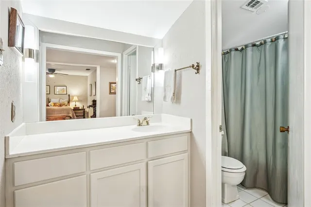 a bathroom with a sink a toilet a mirror and shower