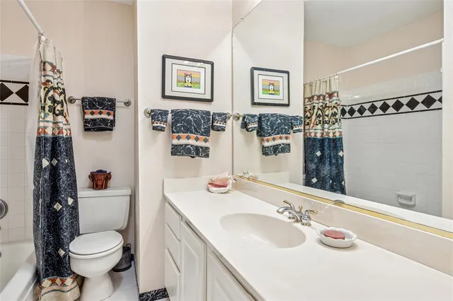 a bathroom with a granite countertop sink mirror vanity and toilet