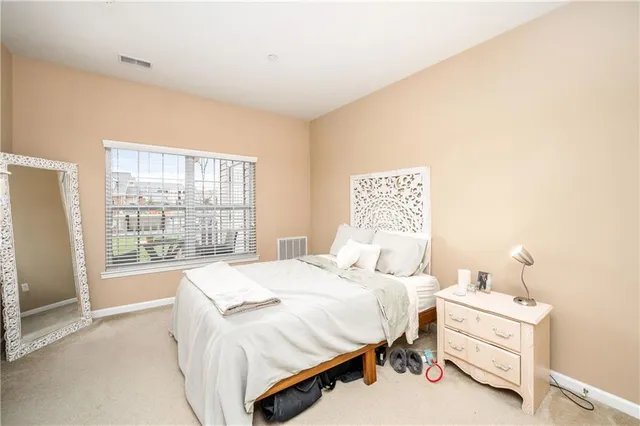 a bedroom with a bed and a large window