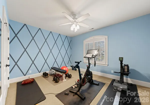 a room with gym equipment and a view of living room