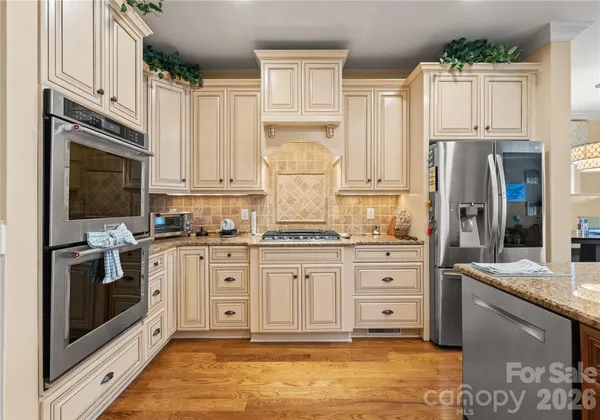 a kitchen with stainless steel appliances granite countertop a stove a sink and a refrigerator