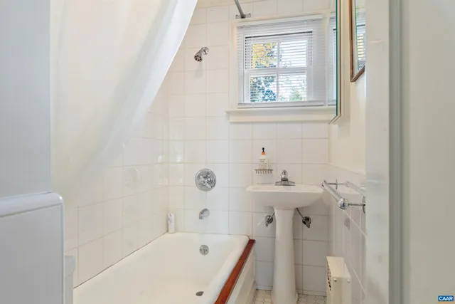 a bathroom with a bathtub sink and mirror