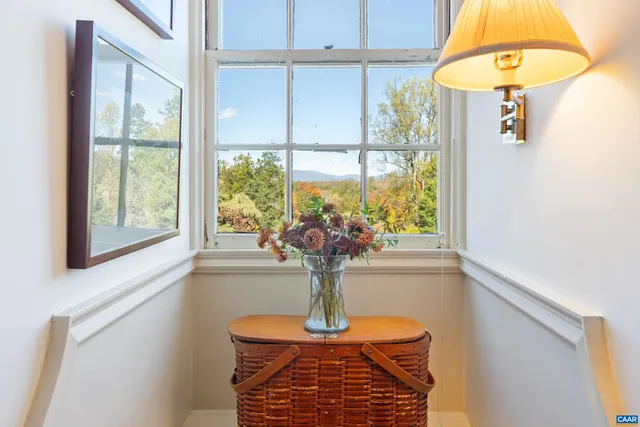 a vase of flowers sitting on a table with a window