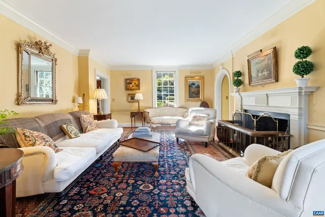 a living room with furniture fireplace and a large window