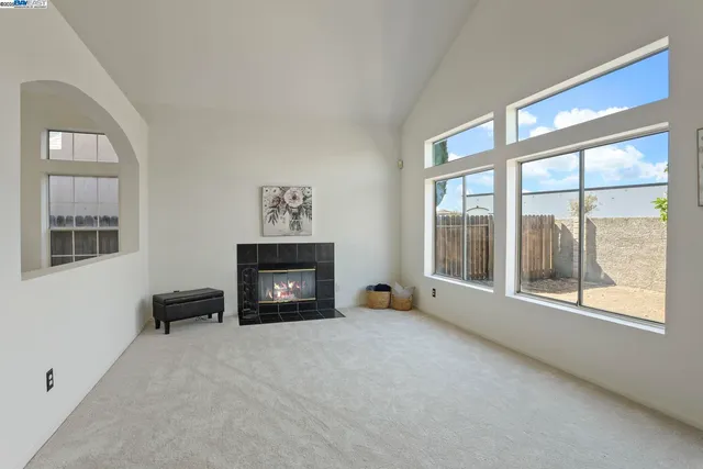 a view of an empty room with a fireplace and a window