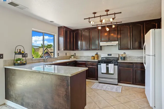 a kitchen with granite countertop a sink stainless steel appliances and cabinets