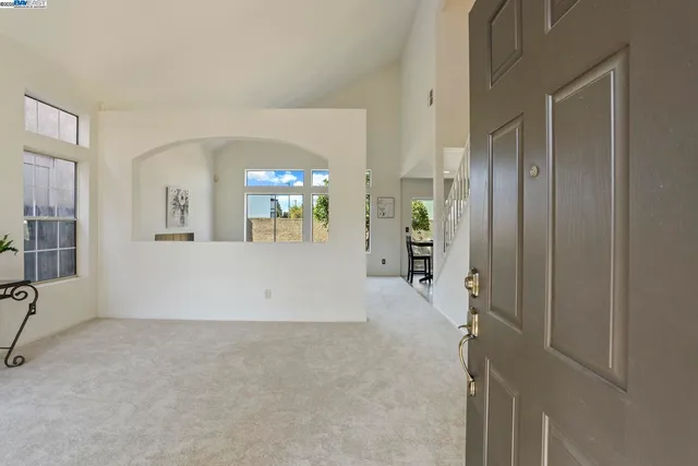 a view of a hallway with wooden floor and a living room