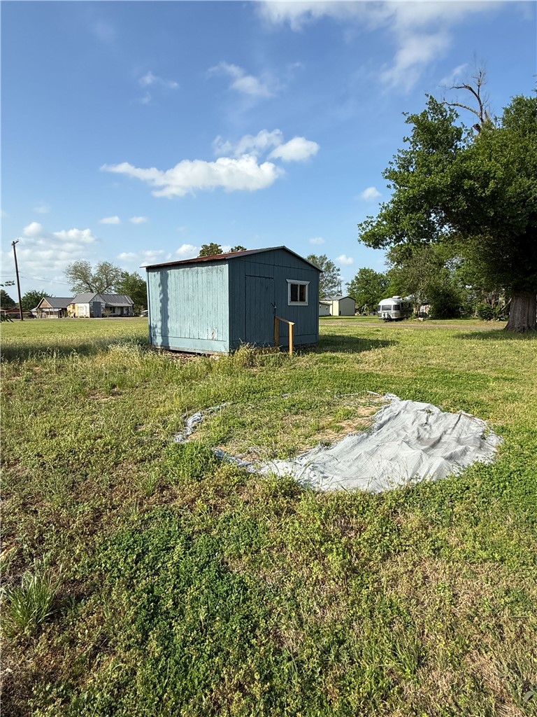 507 Logan Street Calvert, TX 77837 - Photo 15 of 19 View of grassy yard featuring a storage shed