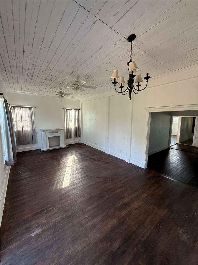 507 Logan Street Calvert, TX 77837 - Photo 2 of 19 Unfurnished living room with wooden ceiling, dark wood-style flooring, suspended lighting, and ceiling fan