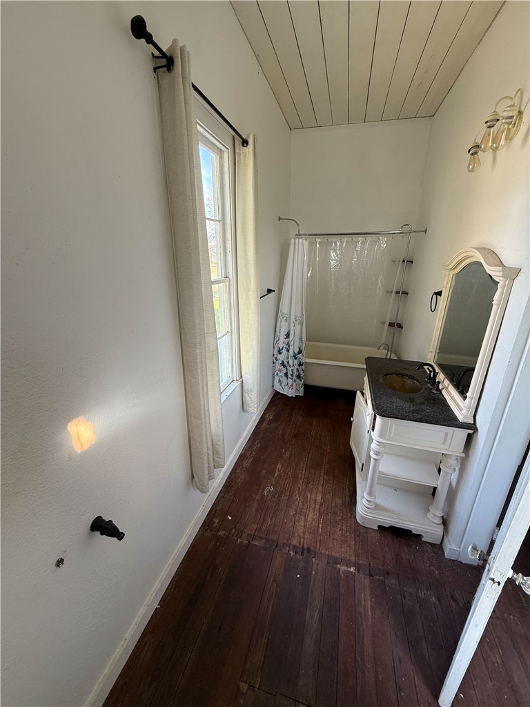 507 Logan Street Calvert, TX 77837 - Photo 7 of 19 Bathroom featuring vanity, dark wood-style flooring, shower / bath combination with curtain, and wood ceiling