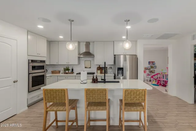 a kitchen with refrigerator a stove a dining table and chairs