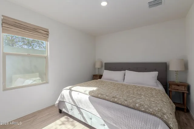 a large bed sitting in a bedroom next to a window