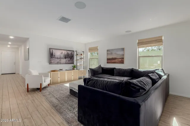 a living room with furniture and a wooden floor