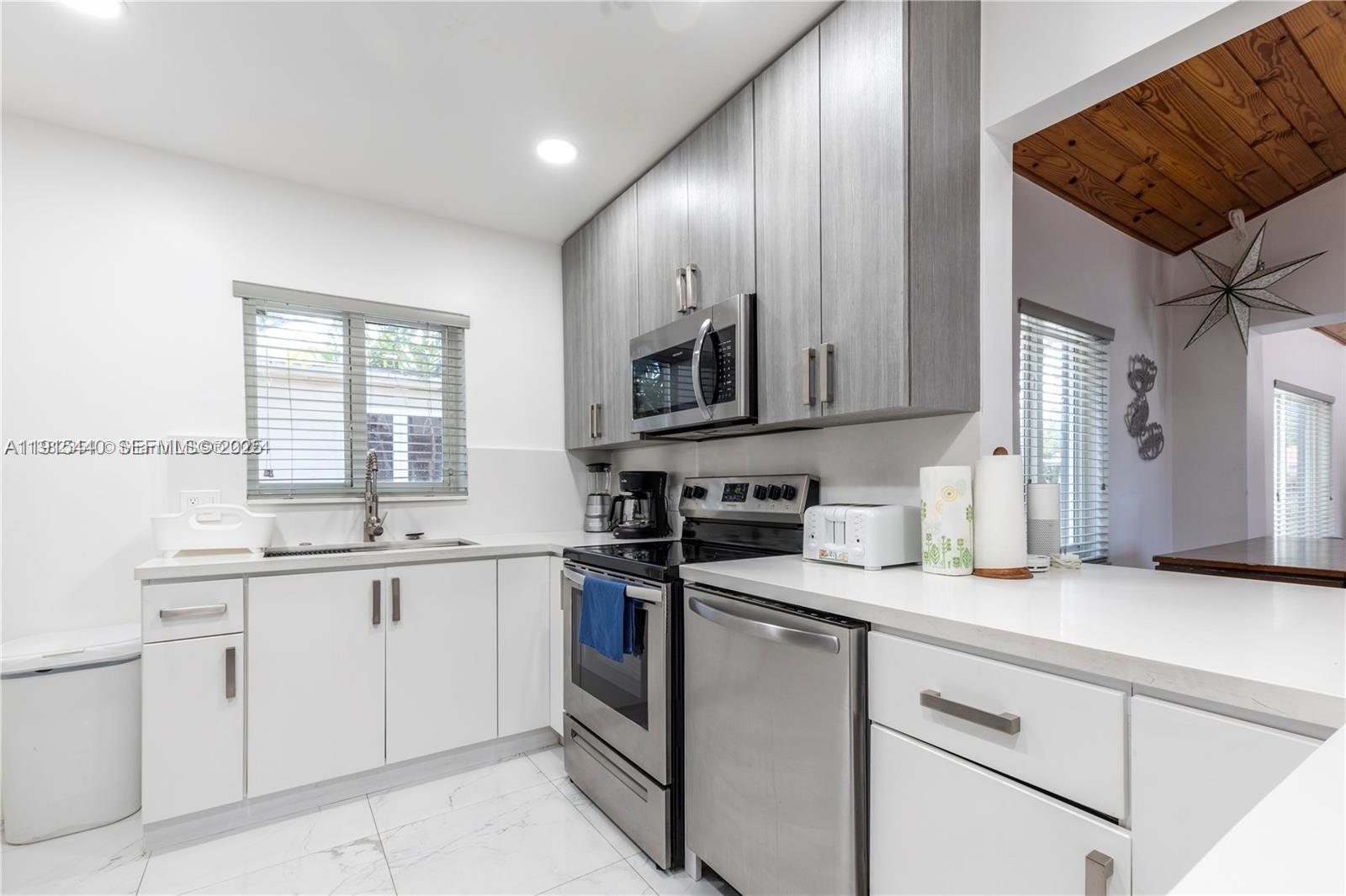 753 Northeast 81st Street Miami, FL 33138 - Photo 18 of 57 a kitchen with a sink stove and microwave