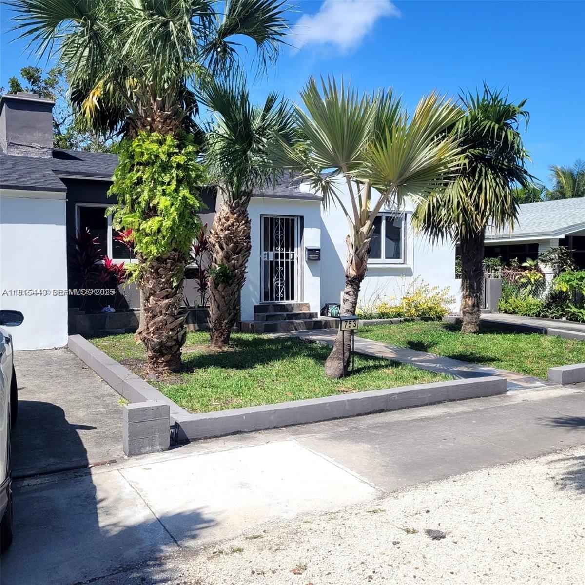 753 Northeast 81st Street Miami, FL 33138 - Photo 3 of 57 a front view of house with small garden and palm trees