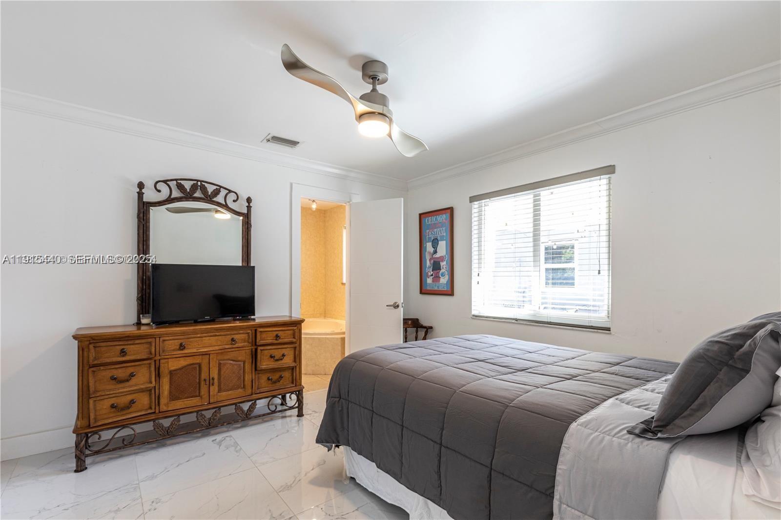 753 Northeast 81st Street Miami, FL 33138 - Photo 32 of 57 a bedroom with a bed and a flat screen tv