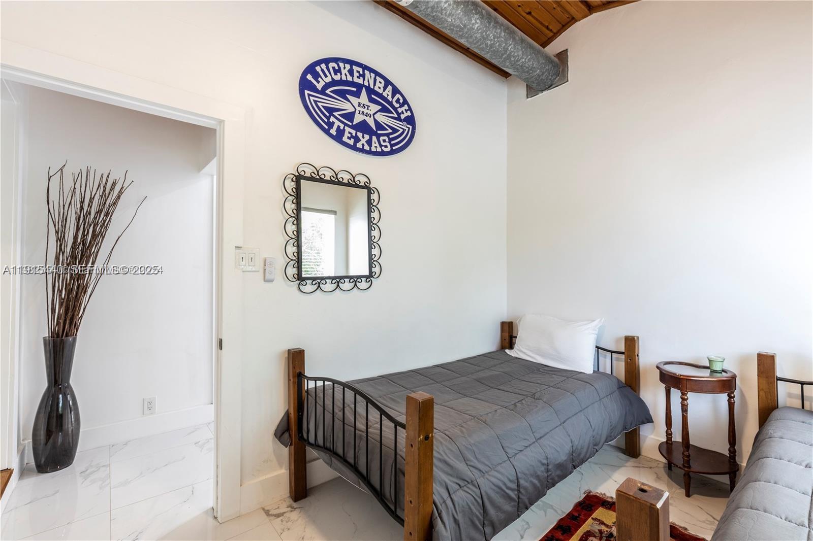 753 Northeast 81st Street Miami, FL 33138 - Photo 35 of 57 a bedroom with a bed and a table in it