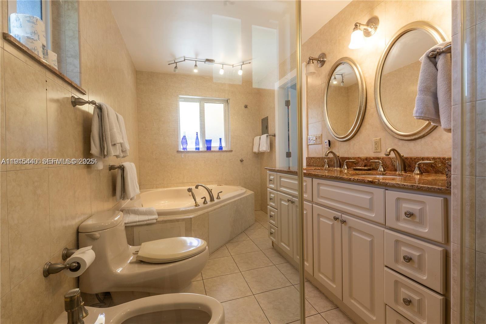 753 Northeast 81st Street Miami, FL 33138 - Photo 49 of 57 a bathroom with a granite countertop sink mirror toilet and bathtub