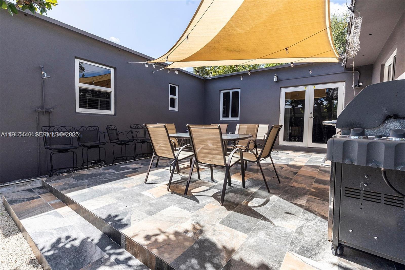 753 Northeast 81st Street Miami, FL 33138 - Photo 52 of 57 a patio with a table and chairs and potted plants