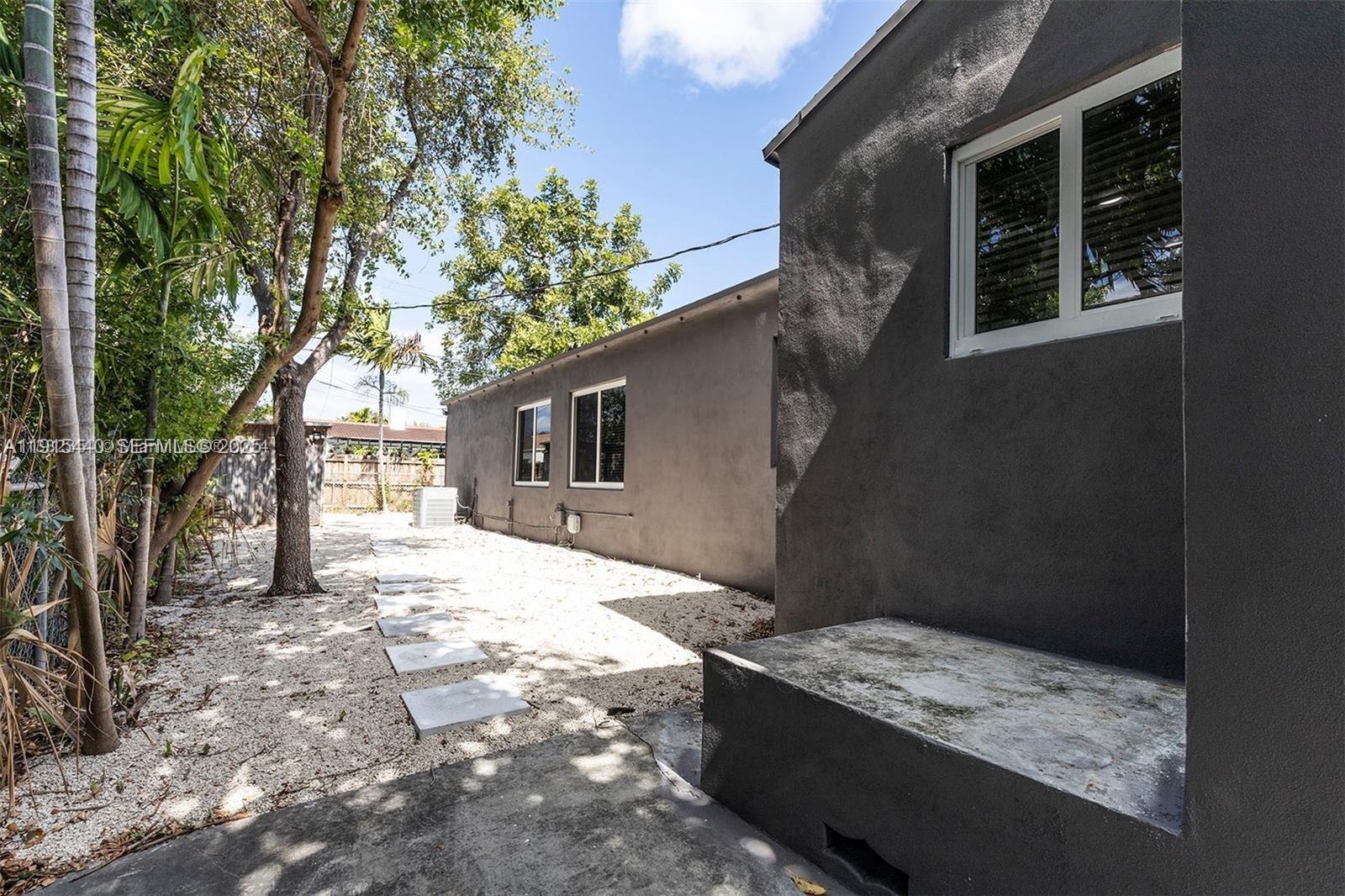 753 Northeast 81st Street Miami, FL 33138 - Photo 56 of 57 a house with trees in front of it