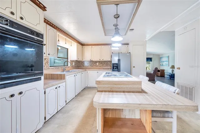 a large kitchen with kitchen island a counter space a sink appliances and cabinets