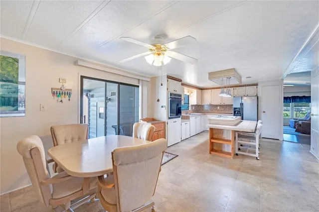 a living room with furniture a chandelier fan and a window