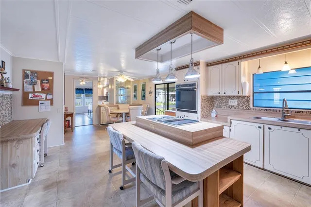a room with stainless steel appliances kitchen island a table and chairs in it