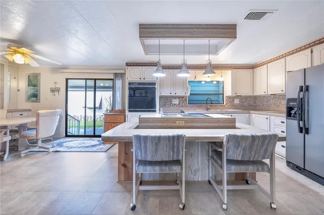 a dining room with a table chairs and a kitchen view