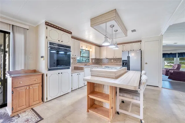 a kitchen with a table chairs refrigerator and cabinets