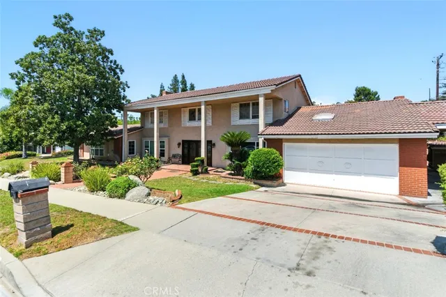 a front view of a house with a yard and potted plants