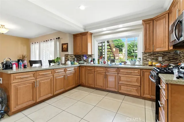 a kitchen with stainless steel appliances granite countertop a stove a sink and a refrigerator