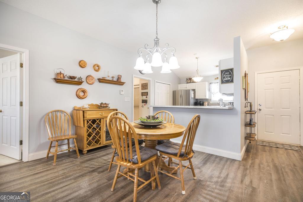 216 South Houston Springs Boulevard Perry, GA 31069 - Photo 11 of 31 a dining room with furniture a chandelier and wooden floor