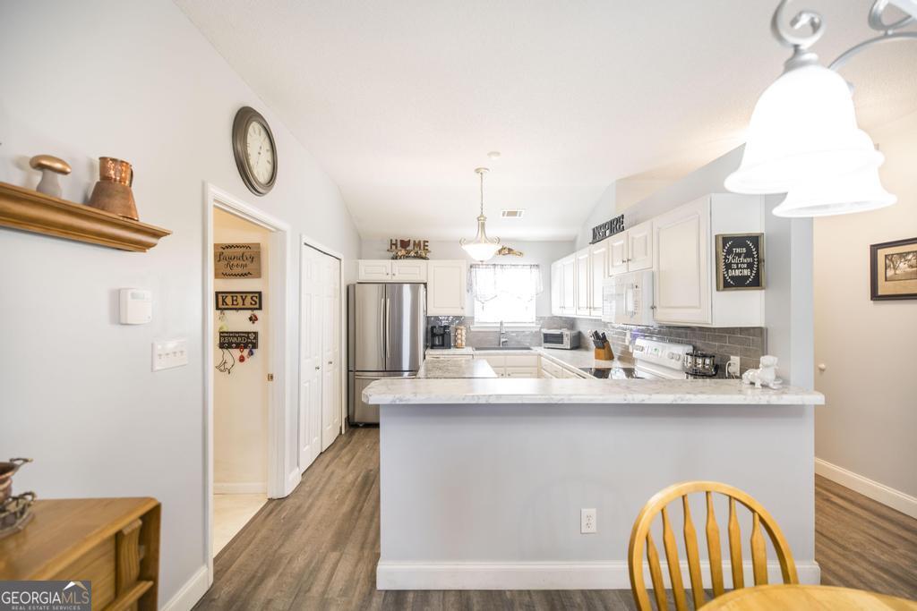 216 South Houston Springs Boulevard Perry, GA 31069 - Photo 12 of 31 a kitchen with stainless steel appliances granite countertop a sink a stove and a wooden floors