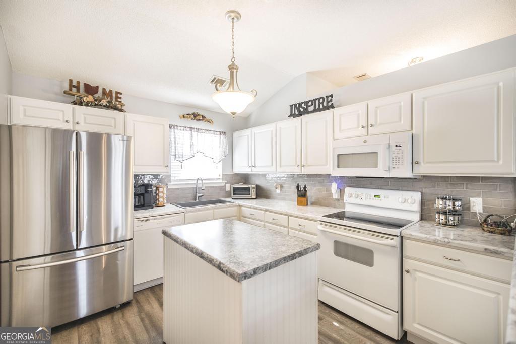216 South Houston Springs Boulevard Perry, GA 31069 - Photo 13 of 31 a kitchen with white cabinets and white appliances