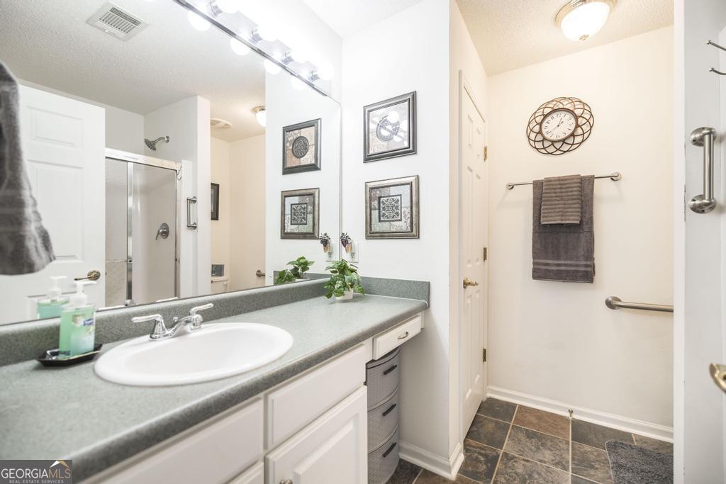 216 South Houston Springs Boulevard Perry, GA 31069 - Photo 19 of 31 a bathroom with a granite countertop sink and a mirror