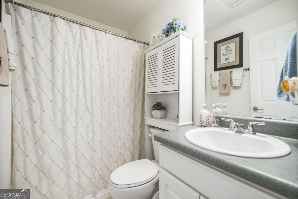 216 South Houston Springs Boulevard Perry, GA 31069 - Photo 22 of 31 a bathroom with a granite countertop sink and a mirror