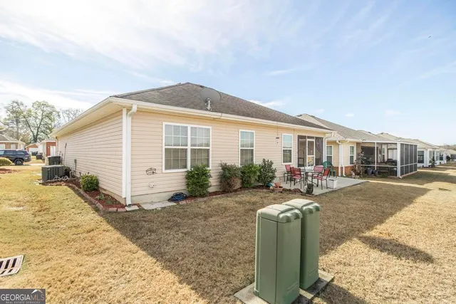 a view of a house with backyard and sitting area