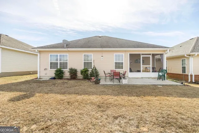 a view of a house with backyard and a tree