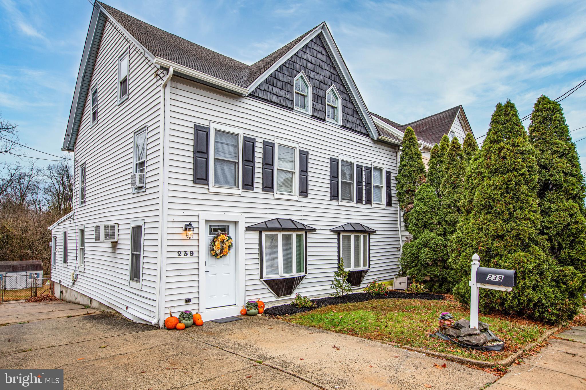 a view of a white house with a sink and yard next to a road