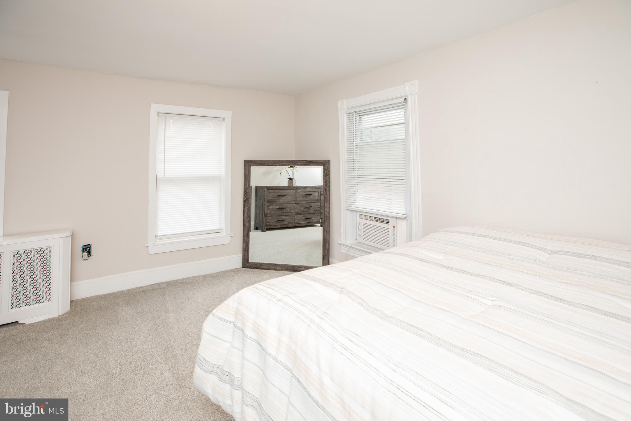 239 Main Street Hamilton, NJ 08620 - Photo 26 of 39 a spacious bedroom with a bed and a window