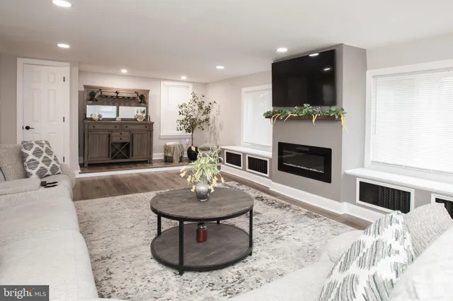 a living room with furniture a fireplace and a flat screen tv
