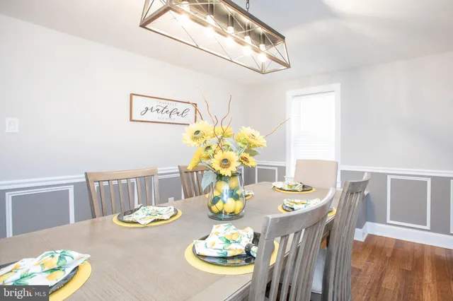 a view of a dining room with furniture a chandelier and wooden floor