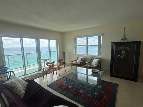 a living room with furniture and a floor to ceiling window