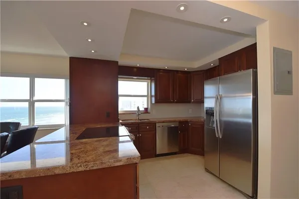 a kitchen with stainless steel appliances granite countertop a sink and a refrigerator