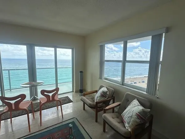 a living room with furniture and floor to ceiling windows