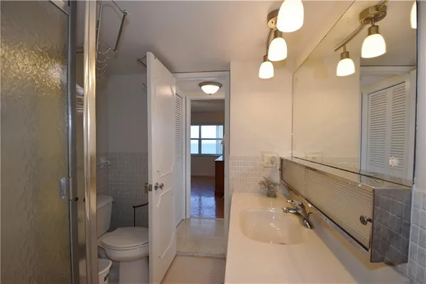 a spacious bathroom with a granite countertop sink mirror vanity and toilet